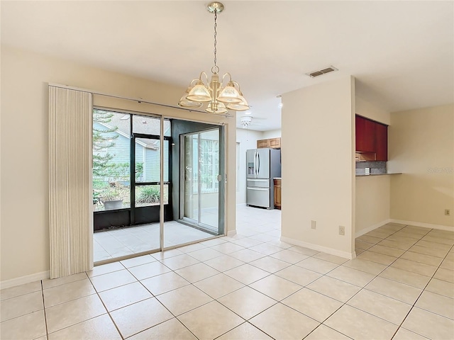 tiled empty room featuring a chandelier