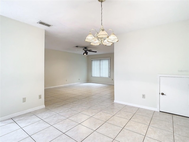 spare room featuring light tile patterned flooring and ceiling fan with notable chandelier