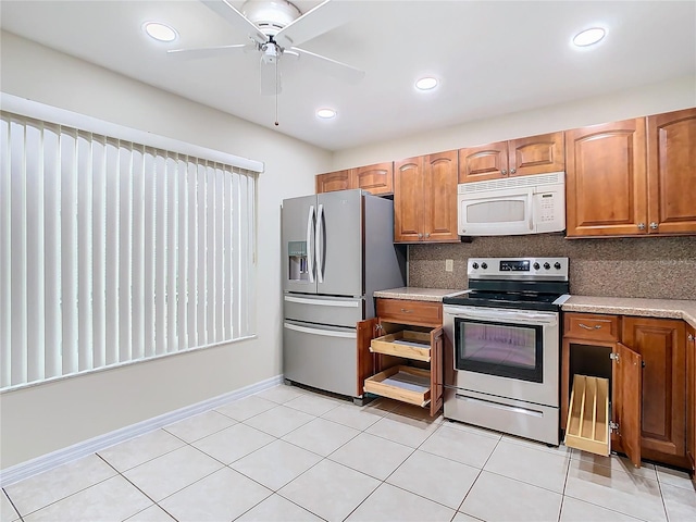 kitchen featuring appliances with stainless steel finishes, light tile patterned floors, ceiling fan, and decorative backsplash