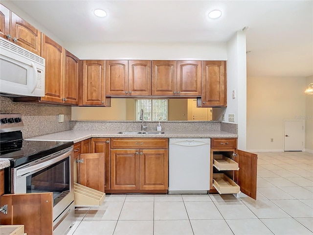 kitchen with sink, decorative backsplash, light tile patterned floors, light stone counters, and white appliances