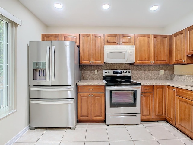 kitchen with stainless steel appliances, light tile patterned flooring, and decorative backsplash