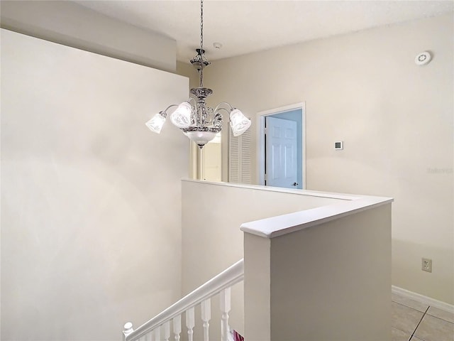 corridor featuring light tile patterned floors and a notable chandelier