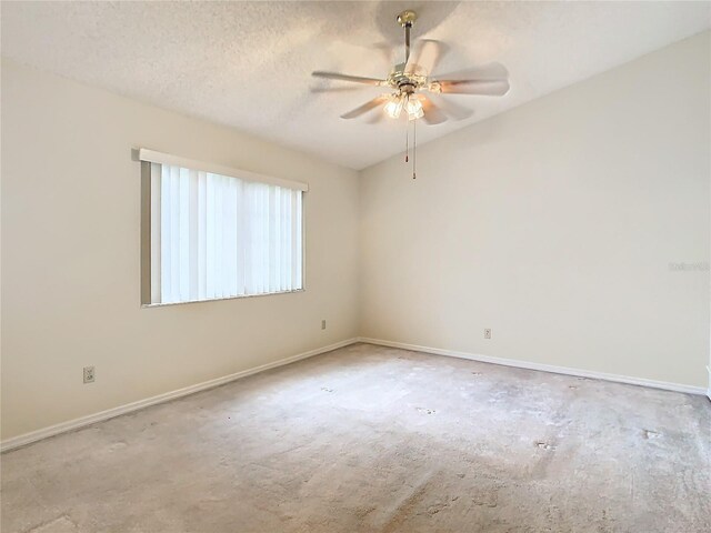 spare room featuring ceiling fan, lofted ceiling, and a textured ceiling