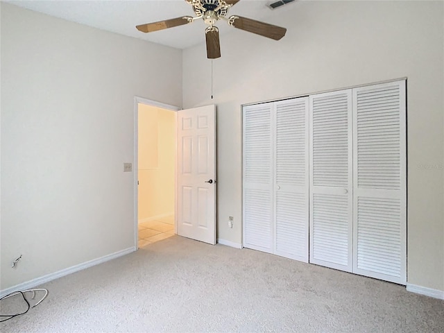 unfurnished bedroom with light carpet, a closet, and ceiling fan