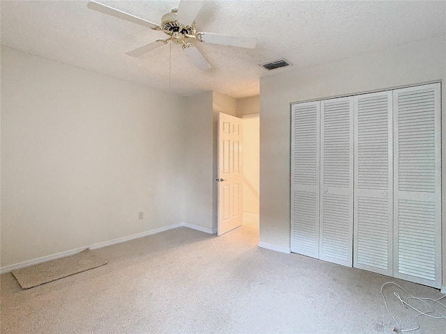 unfurnished bedroom featuring a textured ceiling, ceiling fan, and a closet