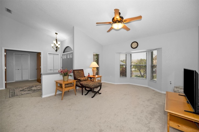 living area with ceiling fan with notable chandelier, light carpet, and high vaulted ceiling