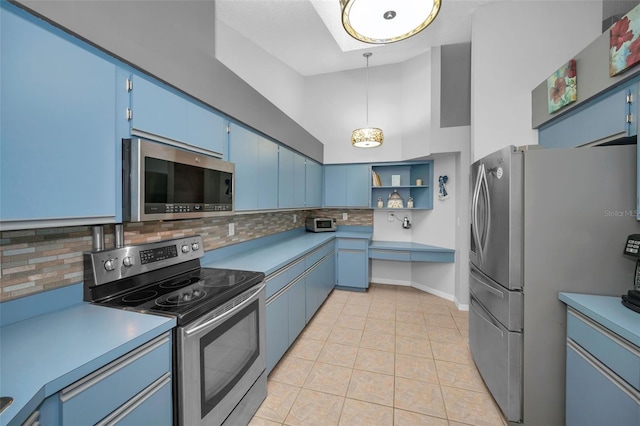 kitchen with blue cabinets, decorative backsplash, a high ceiling, and appliances with stainless steel finishes