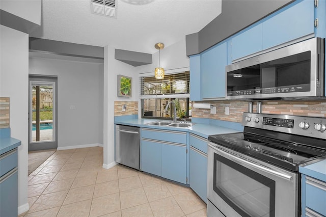 kitchen with appliances with stainless steel finishes, pendant lighting, sink, plenty of natural light, and blue cabinetry