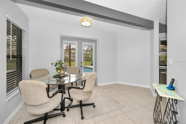 tiled dining room with french doors and a textured ceiling