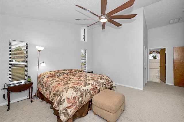 bedroom with light carpet, a textured ceiling, ceiling fan, and ensuite bathroom