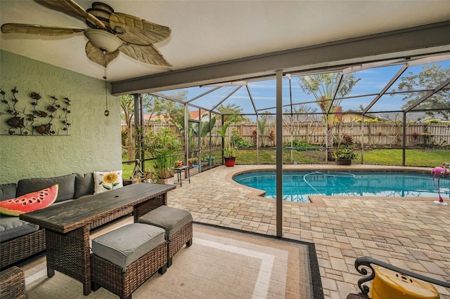 view of pool with ceiling fan, a patio, and glass enclosure