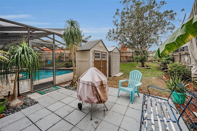 view of patio / terrace with a fenced in pool, a lanai, and a storage unit