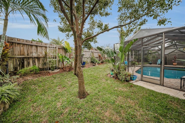 view of yard with a fenced in pool and glass enclosure