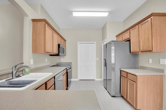 kitchen featuring light tile patterned flooring, appliances with stainless steel finishes, and sink