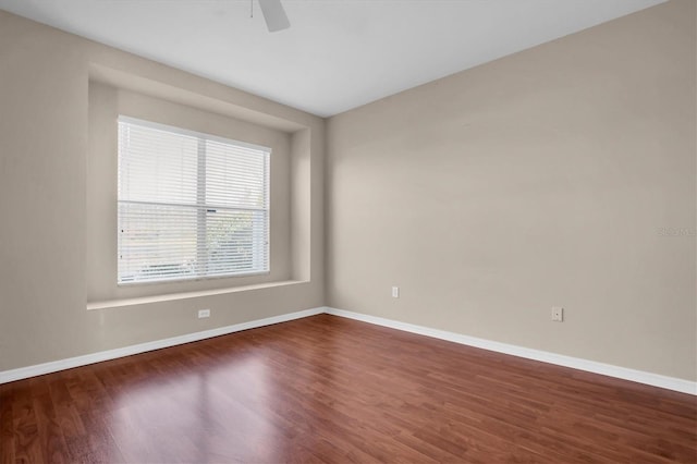 empty room with dark hardwood / wood-style floors and ceiling fan