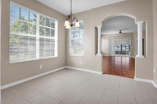 unfurnished dining area with light tile patterned flooring, ceiling fan, and ornate columns