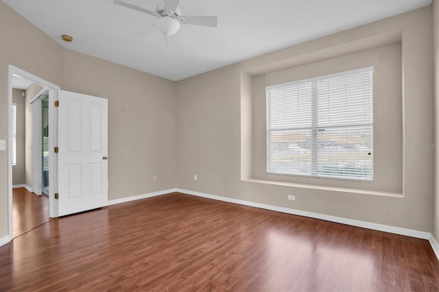 unfurnished room featuring dark wood-type flooring and ceiling fan