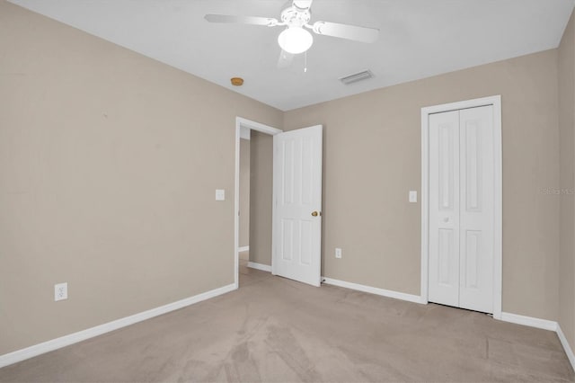 unfurnished bedroom featuring ceiling fan, a closet, and light carpet