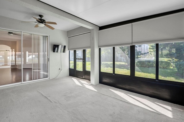 unfurnished sunroom with ceiling fan