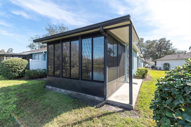 view of property exterior with a lawn and a sunroom