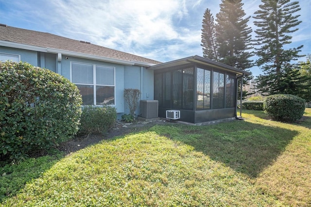 view of side of property featuring a sunroom, central AC unit, and a lawn