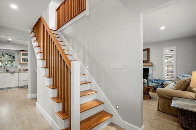 stairs featuring sink and hardwood / wood-style floors