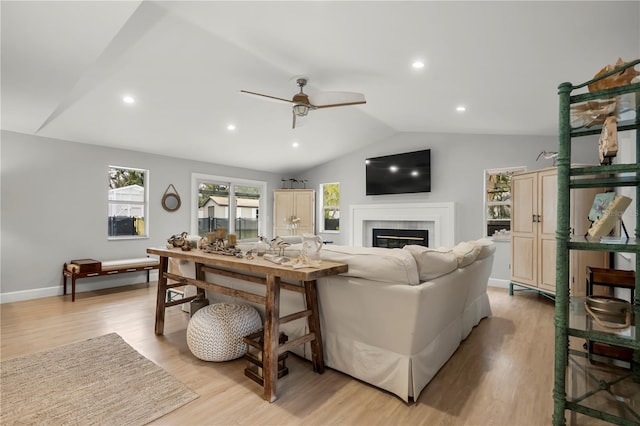 living room featuring ceiling fan, lofted ceiling, and light hardwood / wood-style floors