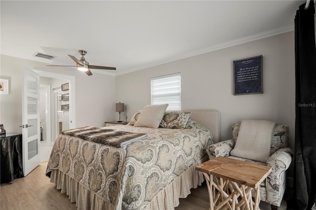 bedroom featuring ornamental molding, light wood-type flooring, and ceiling fan