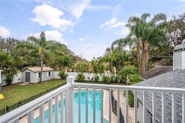 view of pool with a shed and a yard