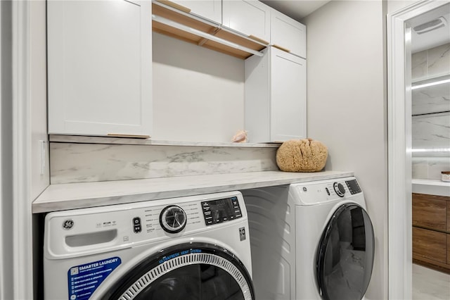 laundry room featuring independent washer and dryer and cabinets