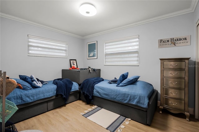 bedroom featuring hardwood / wood-style flooring, ornamental molding, and multiple windows