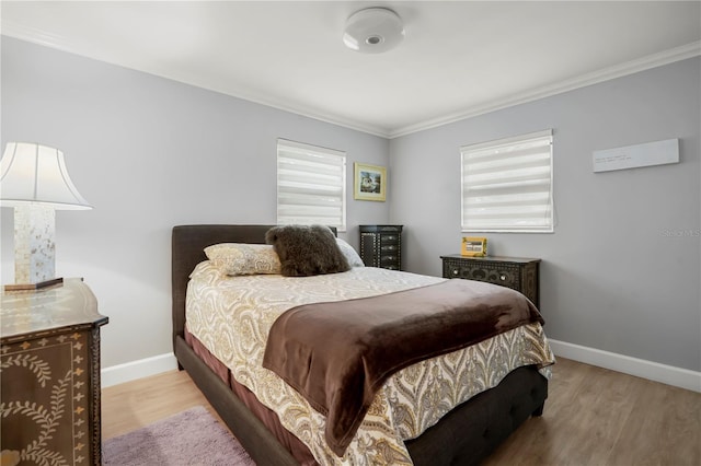 bedroom featuring multiple windows, ornamental molding, and light wood-type flooring