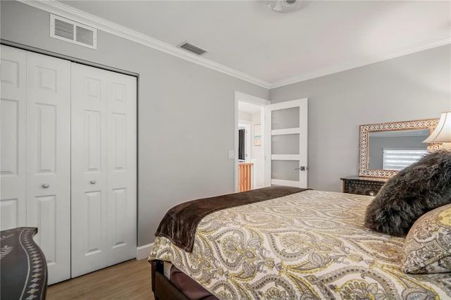 bedroom featuring hardwood / wood-style flooring, crown molding, and a closet