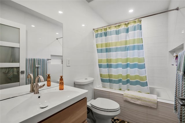 full bathroom with vanity, tile walls, toilet, and shower / bath combo with shower curtain