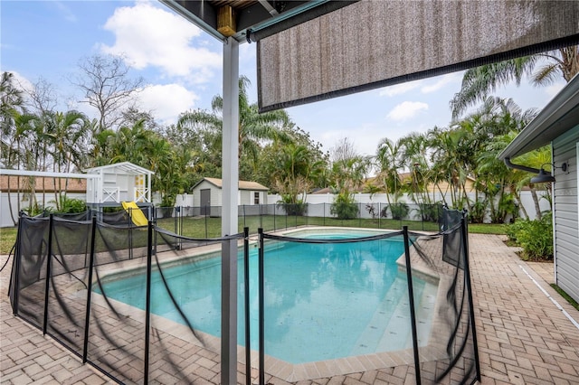 view of pool featuring a yard and a storage unit