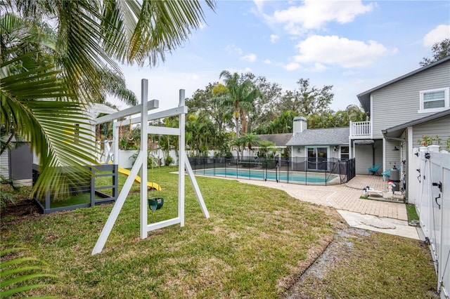 view of yard featuring a fenced in pool, a patio, and a balcony