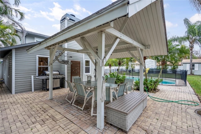 view of patio / terrace featuring area for grilling, a fenced in pool, a gazebo, and a storage shed