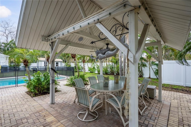 view of patio featuring a fenced in pool, a gazebo, ceiling fan, and a shed