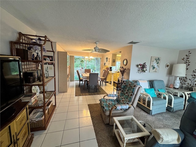 tiled living room with ceiling fan and a textured ceiling