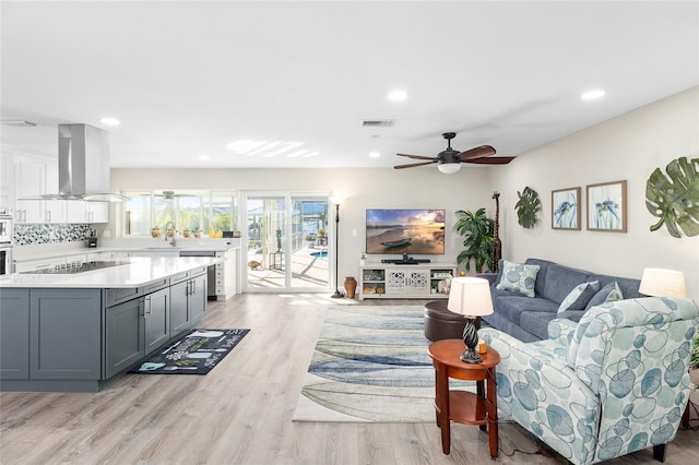 living room with ceiling fan, sink, and light hardwood / wood-style floors