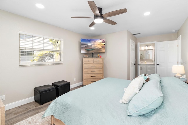 bedroom featuring ceiling fan, connected bathroom, and light wood-type flooring