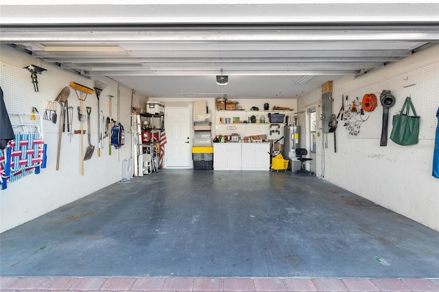 garage with a garage door opener, electric water heater, electric panel, and a workshop area