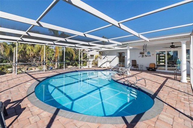 view of swimming pool with ceiling fan, a lanai, and a patio