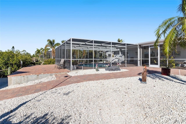 rear view of property with a patio area and glass enclosure