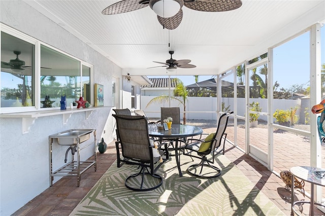 sunroom featuring ceiling fan