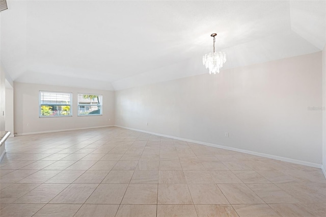 tiled spare room featuring an inviting chandelier, a tray ceiling, and vaulted ceiling