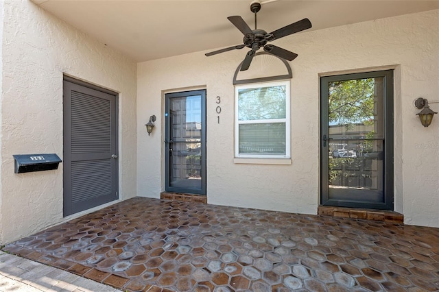 doorway to property with ceiling fan and a patio area