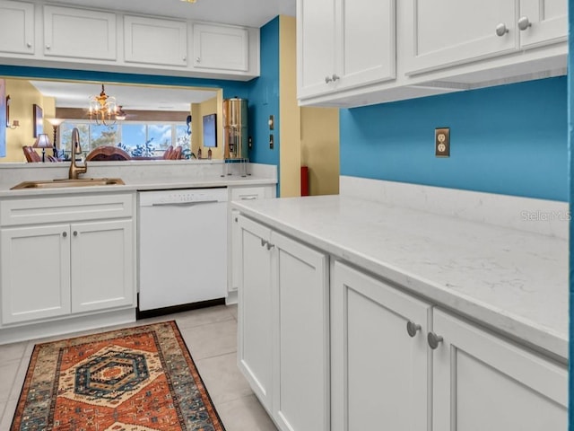 kitchen featuring light tile patterned floors, a sink, white cabinets, dishwasher, and an inviting chandelier