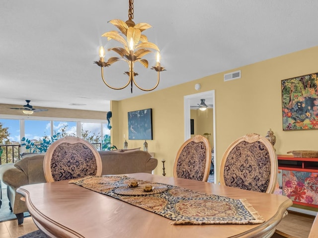 dining room featuring visible vents and ceiling fan with notable chandelier