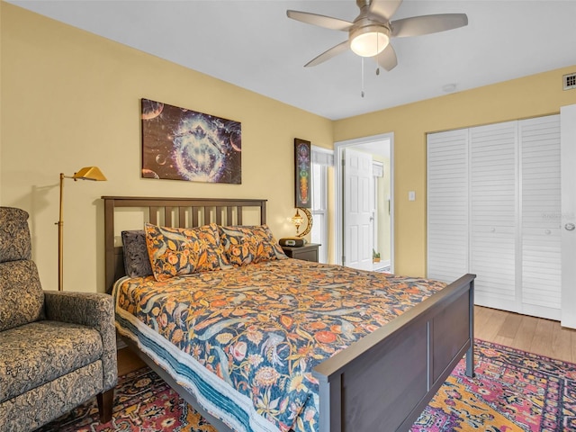 bedroom featuring a closet, visible vents, ceiling fan, and wood finished floors